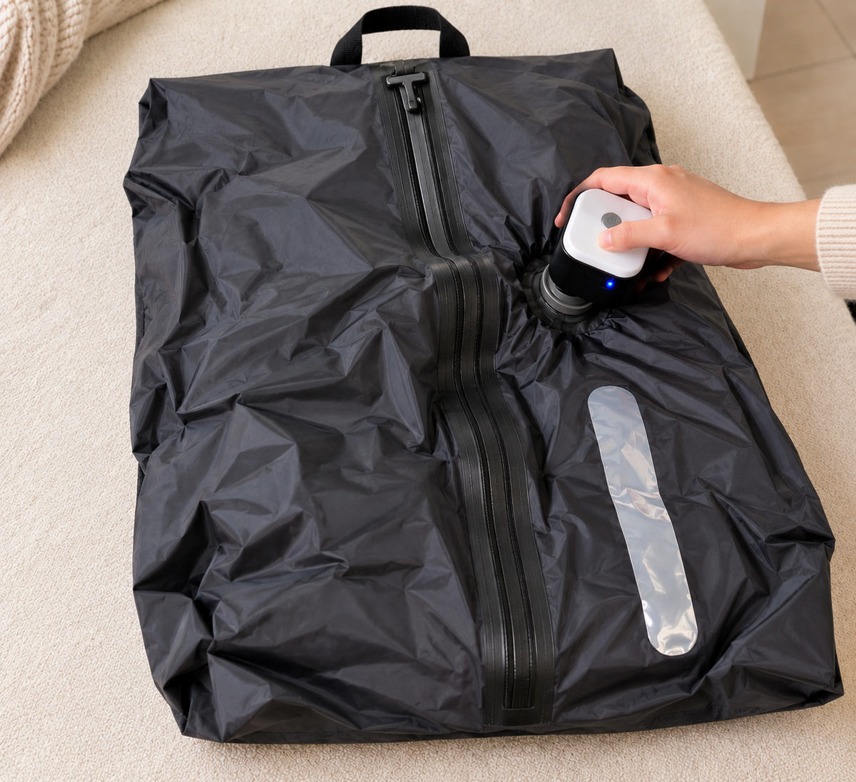 The rechargeable pump drawing air out of the TrekFold™ bag